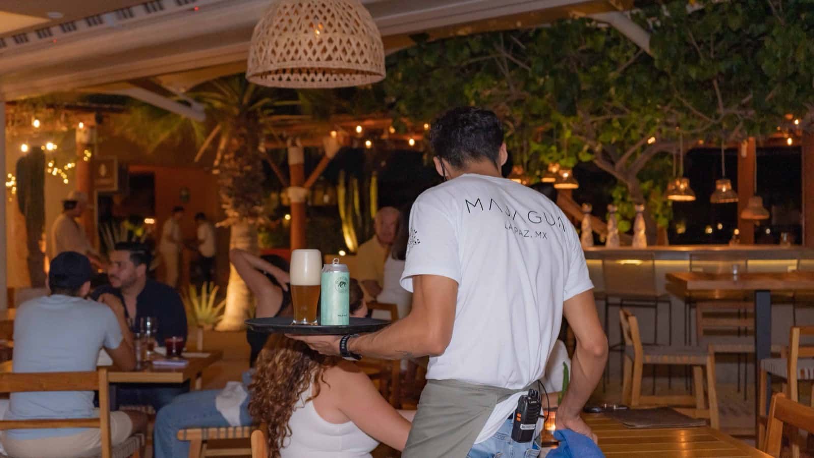 Mesa larga montada para una cena privada bajo la pérgola